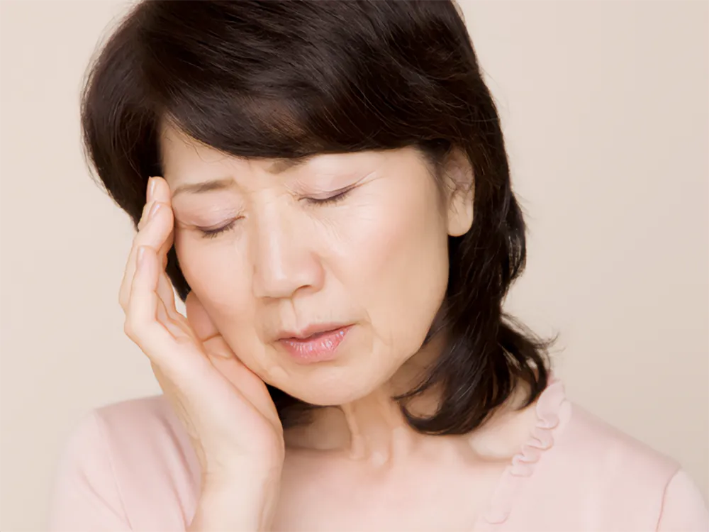 こめかみを抑える女性